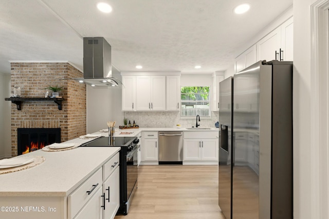 4923 Lofty Pines Cir E, Jacksonville, FL 32210 - kitchen with stainless steel appliances, ventilation hood, light countertops, light wood-type flooring, and white cabinets