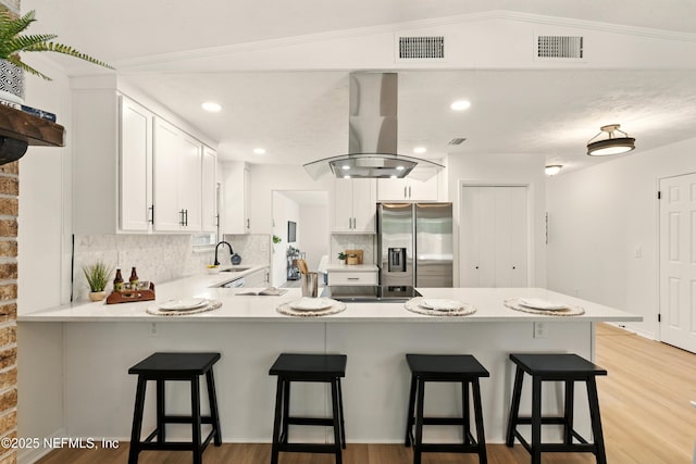 4923 Lofty Pines Cir E, Jacksonville, FL 32210 - kitchen featuring stainless steel fridge with ice dispenser, island range hood, a peninsula, decorative backsplash, and a sink