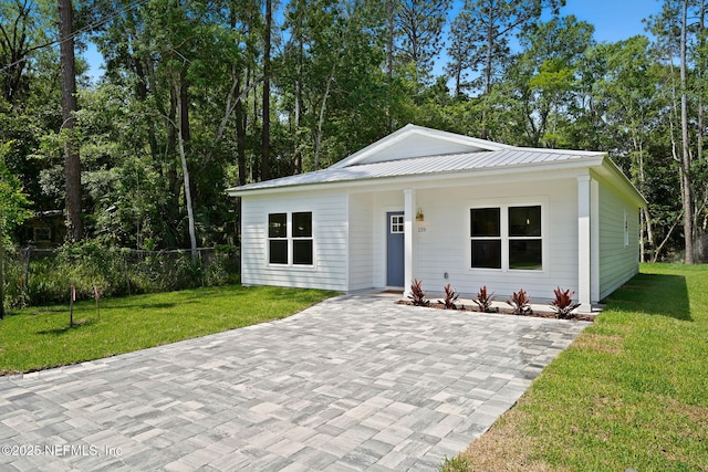view of front of house with metal roof and a patio