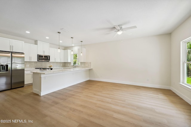 kitchen with stainless steel appliances, light countertops, healthy amount of natural light, and recessed lighting