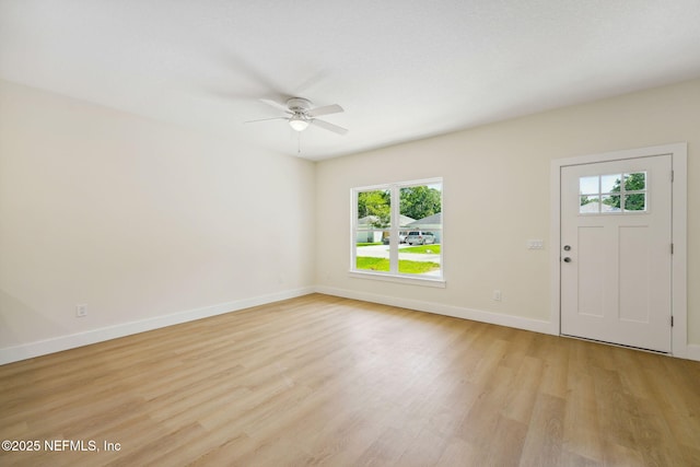 foyer featuring plenty of natural light, light wood-style floors, ceiling fan, and baseboards