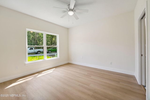 unfurnished room with light wood finished floors, baseboards, and a ceiling fan