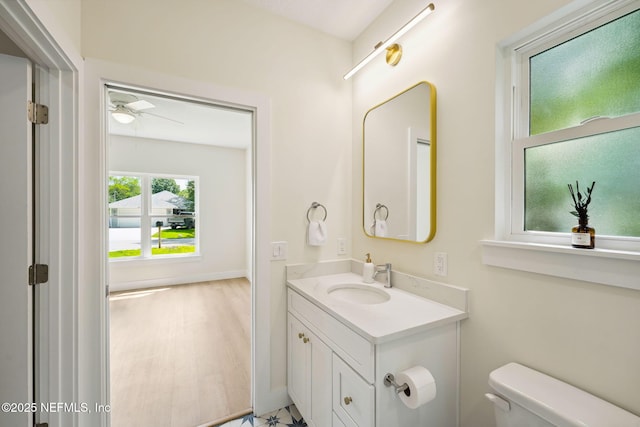 bathroom with toilet, vanity, and a ceiling fan