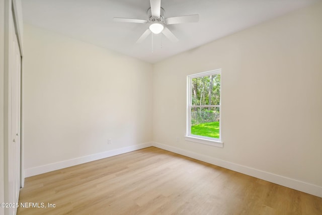 empty room featuring baseboards, light wood-style floors, and a ceiling fan
