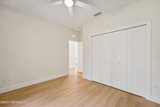 unfurnished bedroom with wood finished floors, baseboards, and a closet