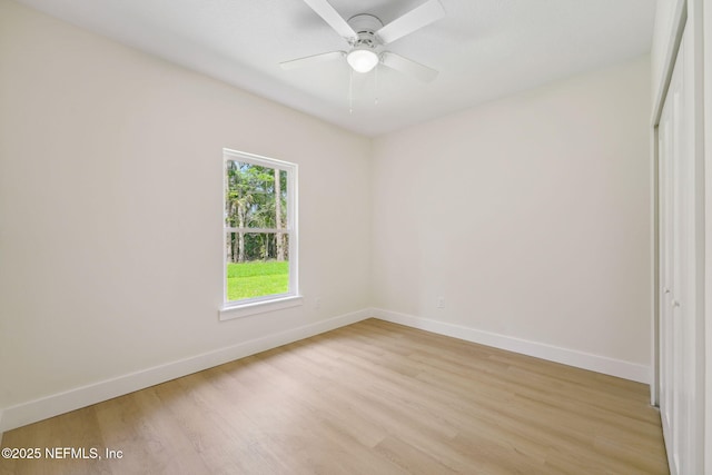 unfurnished room with baseboards, light wood-type flooring, and a ceiling fan