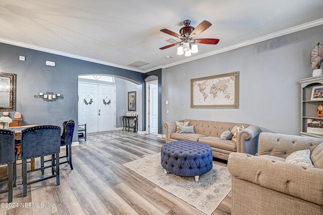 3051 Paddle Creek Dr, Green Cove Springs, FL 32043 - living room featuring arched walkways, wood finished floors, a ceiling fan, crown molding, and baseboards