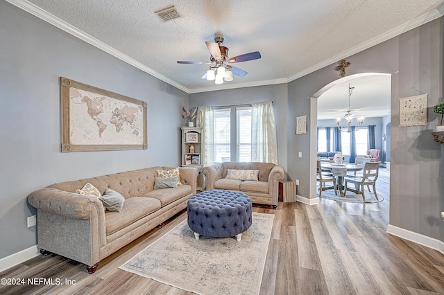3051 Paddle Creek Dr, Green Cove Springs, FL 32043 - living room featuring a chandelier, wood finished floors, arched walkways, ceiling fan, and a textured ceiling