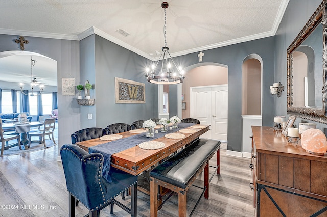 3051 Paddle Creek Dr, Green Cove Springs, FL 32043 - dining room featuring light wood-style floors, a chandelier, a textured ceiling, arched walkways, and a ceiling fan