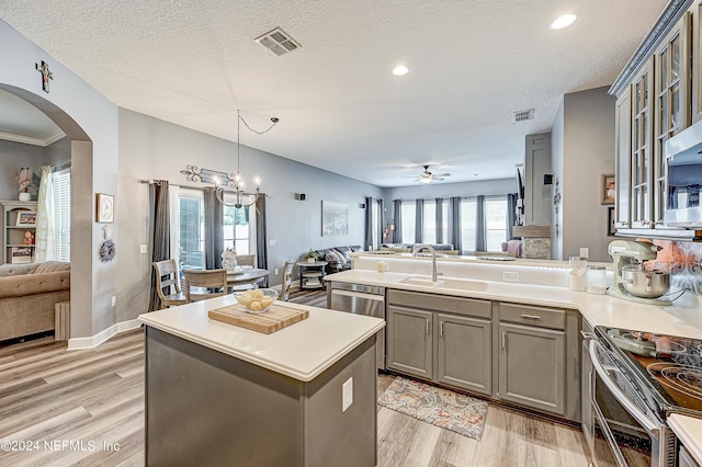 3051 Paddle Creek Dr, Green Cove Springs, FL 32043 - kitchen with open floor plan, arched walkways, a peninsula, light wood-type flooring, and a textured ceiling