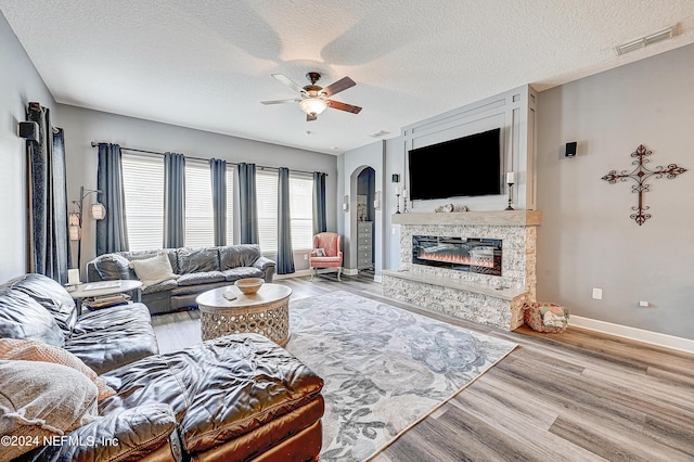 3051 Paddle Creek Dr, Green Cove Springs, FL 32043 - living area with a textured ceiling, arched walkways, a ceiling fan, wood finished floors, and baseboards