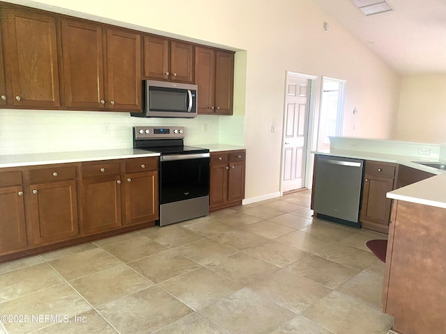 2253 S Mimosa Ave, Middleburg, FL 32068 - kitchen with stainless steel appliances, decorative backsplash, light countertops, high vaulted ceiling, and brown cabinets