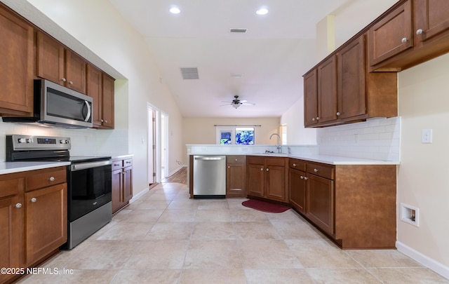 2253 S Mimosa Ave, Middleburg, FL 32068 - kitchen featuring stainless steel appliances, decorative backsplash, light countertops, a peninsula, and lofted ceiling