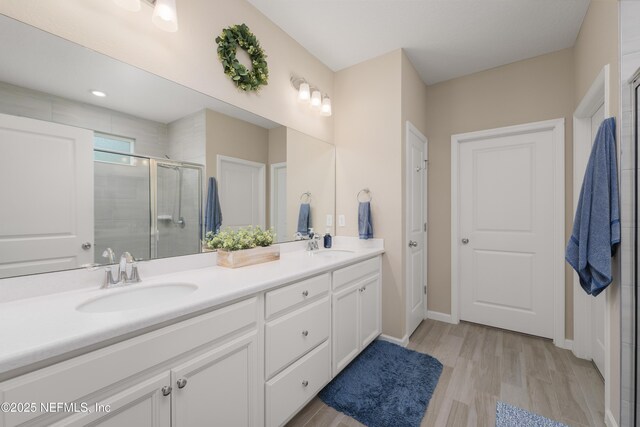 222 River Mist Dr, Saint Augustine, FL 32095 - full bathroom with double vanity, a stall shower, wood finished floors, and baseboards