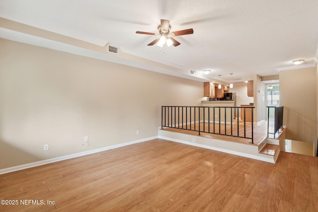 5375 Ortega Farms Blvd Unit 510, Jacksonville, FL 32210 - empty room with a ceiling fan, light wood finished floors, ornamental molding, baseboards, and a textured ceiling