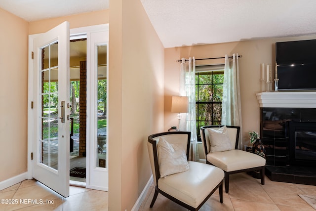 79 Sanchez Dr E, Ponte Vedra Beach, FL 32082 - living area with a tile fireplace, baseboards, tile patterned flooring, and french doors