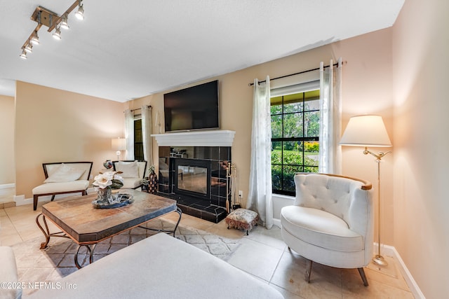 79 Sanchez Dr E, Ponte Vedra Beach, FL 32082 - living room with tile patterned flooring, a tiled fireplace, baseboards, and rail lighting