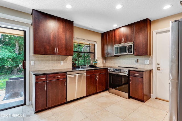 79 Sanchez Dr E, Ponte Vedra Beach, FL 32082 - kitchen with appliances with stainless steel finishes, a sink, tasteful backsplash, recessed lighting, and dark countertops