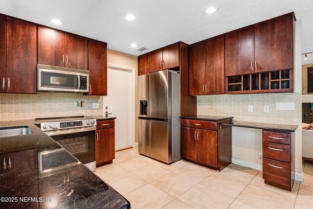 79 Sanchez Dr E, Ponte Vedra Beach, FL 32082 - kitchen with stainless steel appliances, dark stone countertops, tasteful backsplash, light tile patterned floors, and recessed lighting