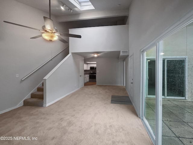 102 Courageous Ct N Unit 102, Jacksonville, FL 32233 - unfurnished living room with carpet flooring, a skylight, stairway, a ceiling fan, and a high ceiling