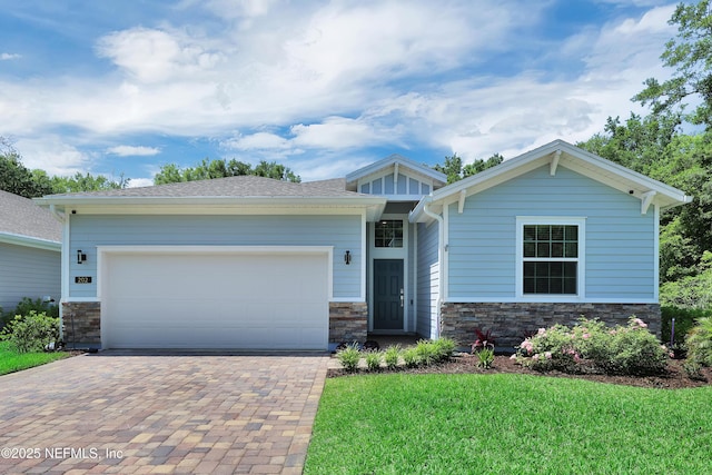 202 Purus Way, Jacksonville, FL 32259 - craftsman house with decorative driveway, stone siding, an attached garage, and a front lawn
