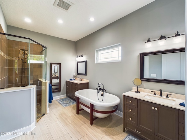 75610 Edwards Rd, Yulee, FL 32097 - bathroom with a stall shower, baseboards, two vanities, a freestanding tub, and recessed lighting