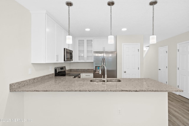 8204 Dandy Ave, Jacksonville, FL 32211 - kitchen with appliances with stainless steel finishes, a sink, a peninsula, glass insert cabinets, and light stone countertops