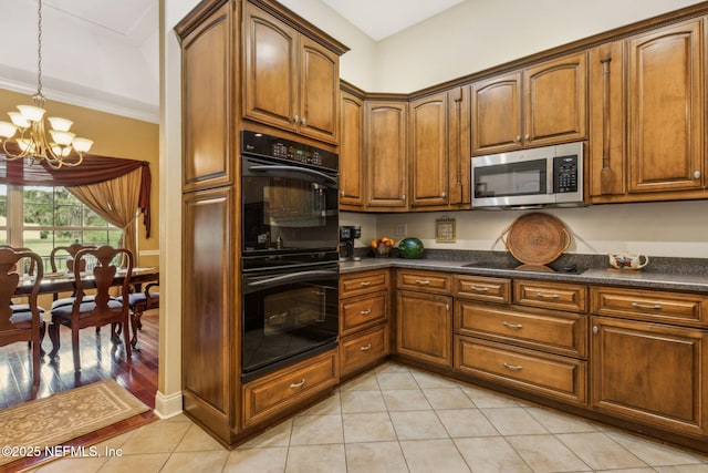 166 Mount Royal Ave, Crescent City, FL 32112 - kitchen with black appliances, a chandelier, dark countertops, light tile patterned flooring, and brown cabinets
