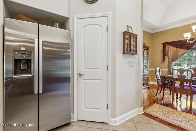 166 Mount Royal Ave, Crescent City, FL 32112 - kitchen featuring stainless steel fridge with ice dispenser, light tile patterned floors, a chandelier, baseboards, and crown molding