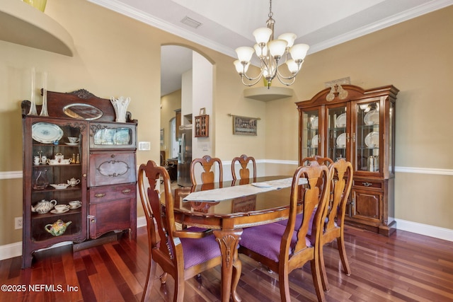 166 Mount Royal Ave, Crescent City, FL 32112 - dining area with arched walkways, a chandelier, dark wood-style floors, baseboards, and crown molding