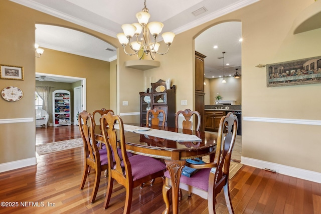 166 Mount Royal Ave, Crescent City, FL 32112 - dining area featuring arched walkways, wood-type flooring, baseboards, a chandelier, and crown molding