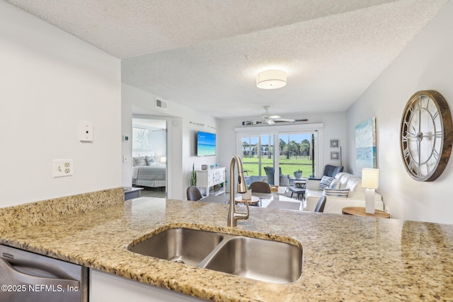 4250 A1A S Unit C15, Saint Augustine, FL 32080 - kitchen featuring a sink, dishwasher, a textured ceiling, light stone countertops, and ceiling fan