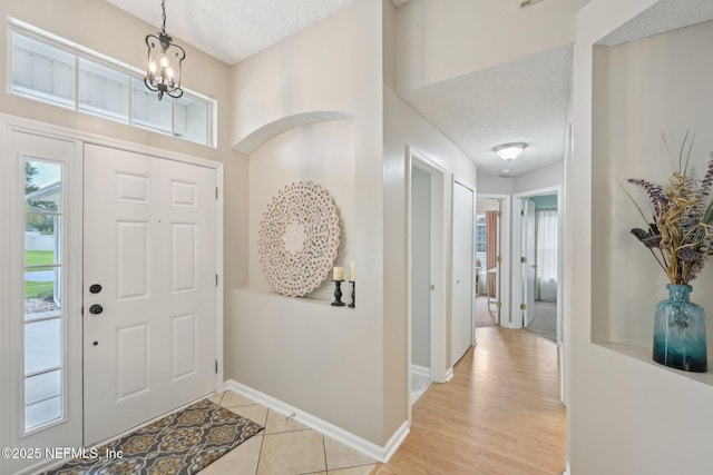 1494 Cedar Grove Ter, Fleming Island, FL 32003 - foyer entrance with a textured ceiling, baseboards, and a chandelier
