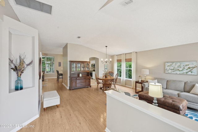 1494 Cedar Grove Ter, Fleming Island, FL 32003 - living room featuring vaulted ceiling, light wood-style flooring, plenty of natural light, baseboards, and a chandelier