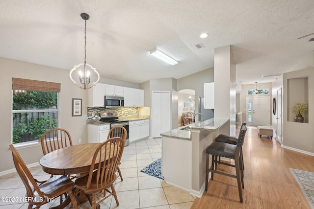 1494 Cedar Grove Ter, Fleming Island, FL 32003 - dining area with a textured ceiling, baseboards, arched walkways, and a chandelier