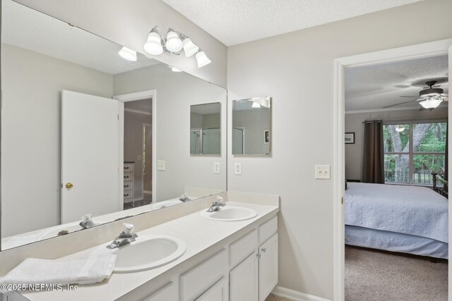 1494 Cedar Grove Ter, Fleming Island, FL 32003 - bathroom featuring ensuite bathroom, double vanity, a textured ceiling, baseboards, and ceiling fan