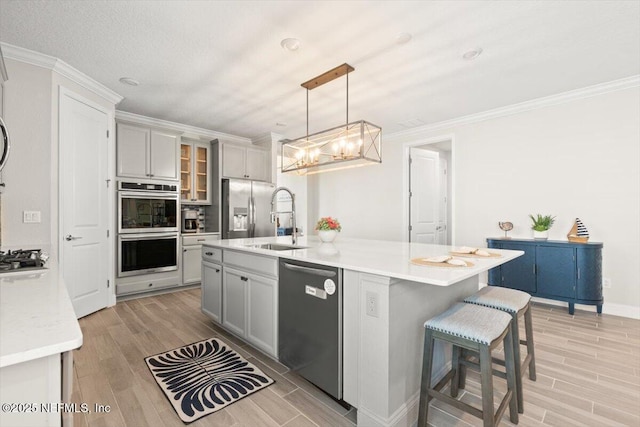 710 Stillwater Blvd, Saint Johns, FL 32259 - kitchen with appliances with stainless steel finishes, a sink, light wood finished floors, a chandelier, and crown molding
