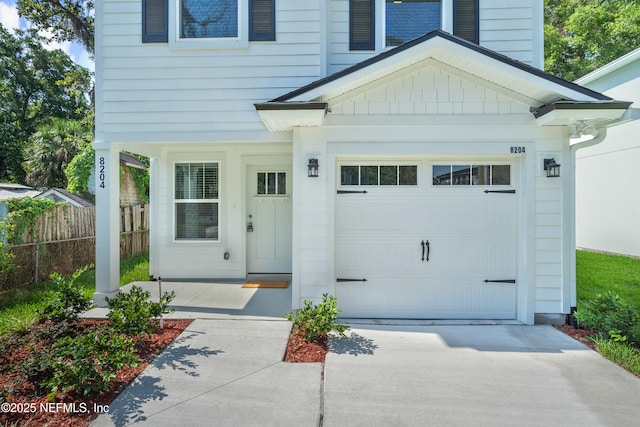 8198 Dandy Ave, Jacksonville, FL 32211 - doorway to property with concrete driveway, an attached garage, and board and batten siding