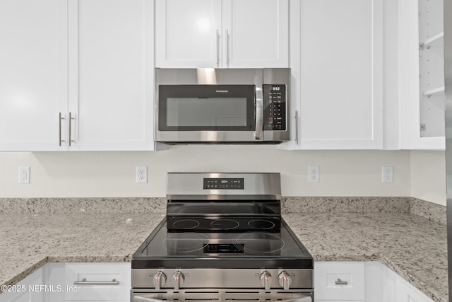 8198 Dandy Ave, Jacksonville, FL 32211 - kitchen featuring stainless steel appliances, white cabinetry, and light stone countertops