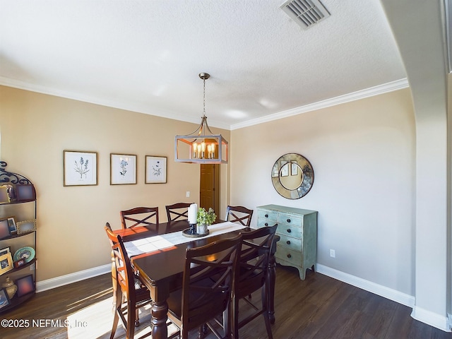 85667 Berryessa Way, Fernandina Beach, FL 32034 - dining room with a chandelier, dark wood-style flooring, ornamental molding, baseboards, and a textured ceiling