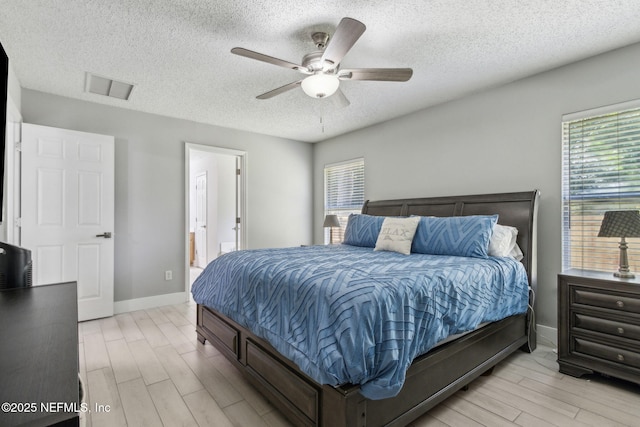 1254 Palisades Dr, Jacksonville, FL 32221 - bedroom featuring light wood-type flooring, multiple windows, a textured ceiling, baseboards, and connected bathroom