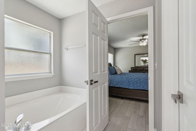 1254 Palisades Dr, Jacksonville, FL 32221 - ensuite bathroom with a textured ceiling, a bath, ceiling fan, and wood finished floors
