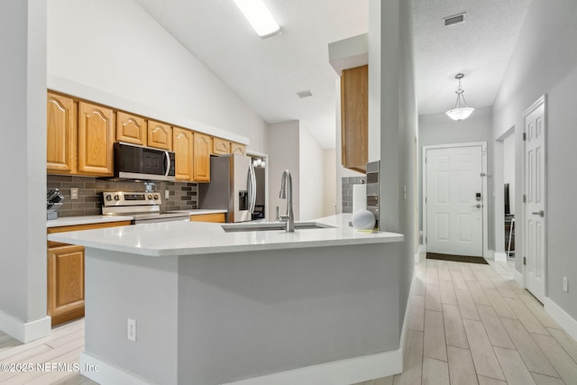 1254 Palisades Dr, Jacksonville, FL 32221 - kitchen featuring appliances with stainless steel finishes, a sink, backsplash, light countertops, and light wood finished floors