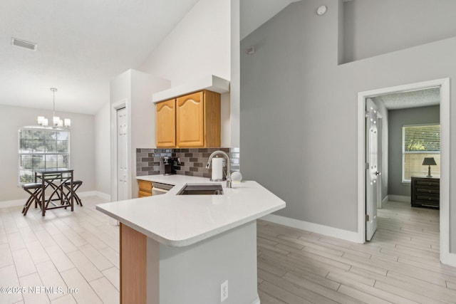 1254 Palisades Dr, Jacksonville, FL 32221 - kitchen with a sink, light countertops, light wood-style flooring, a chandelier, and backsplash