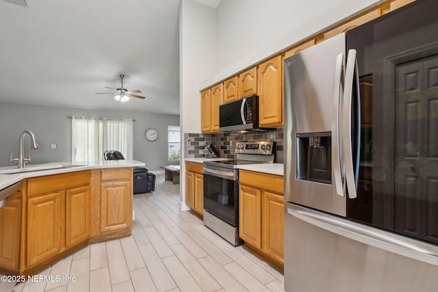 1254 Palisades Dr, Jacksonville, FL 32221 - kitchen with appliances with stainless steel finishes, a sink, light countertops, decorative backsplash, and a ceiling fan