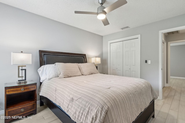 1254 Palisades Dr, Jacksonville, FL 32221 - bedroom featuring a closet, baseboards, light wood-style floors, ceiling fan, and a textured ceiling