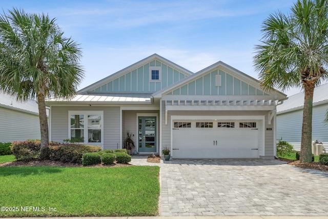 244 Caribbean Pl, Saint Johns, FL 32259 - view of front of property with a front yard, board and batten siding, a garage, decorative driveway, and a standing seam roof