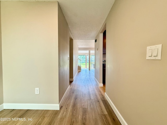 7779 Las Palmas Way Unit 114, Jacksonville, FL 32256 - hall featuring wood finished floors, baseboards, and a textured ceiling
