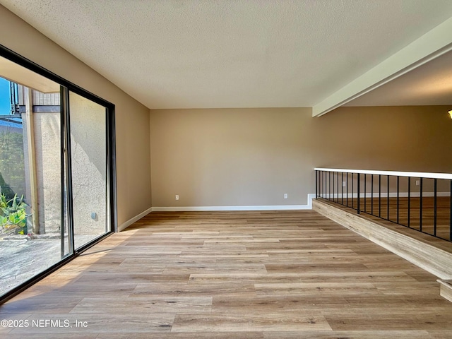 7779 Las Palmas Way Unit 114, Jacksonville, FL 32256 - empty room featuring healthy amount of natural light, light wood-style floors, baseboards, and a textured ceiling