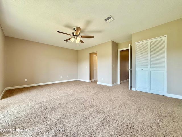 7779 Las Palmas Way Unit 114, Jacksonville, FL 32256 - unfurnished bedroom featuring carpet floors, baseboards, ceiling fan, a closet, and a textured ceiling